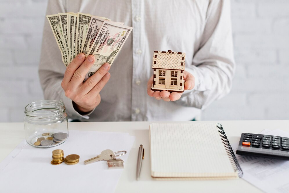 Person with money and home model in his hands